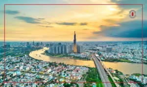 A breathtaking aerial view of Ho Chi Minh City at sunset, showcasing its skyline, the Landmark 81 tower, and the Saigon River. The image represents Vietnam's economic growth and global business opportunities.