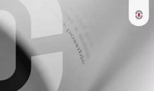 A close-up of a book page with the word "possible" in focus, partially obscured by the curve of the turning page. The blurred background and grayscale tones create a sense of depth and contemplation, emphasizing the role of precision in language quality assurance.