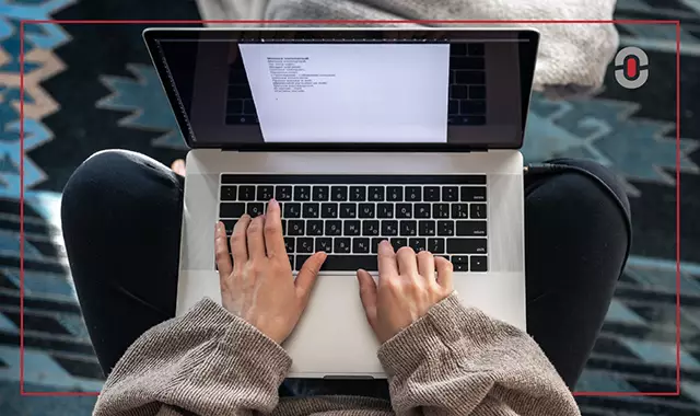 Person typing on a laptop with a document open, symbolizing the practical application of AI translation tools like NMT or LLMs for everyday localization tasks.