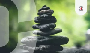 A balanced stack of smooth black stones set against a blurred green background, representing stability, harmony, and the careful layering of AI translation technologies to achieve accuracy and efficiency.