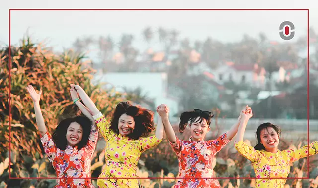 Four Vietnamese women in traditional áo dài dresses smiling and holding hands outdoors, representing cultural pride, unity, and the vibrant spirit of Vietnam.