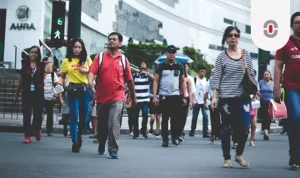 Filipino pedestrians crossing a busy urban street in Metro Manila, reflecting the country’s multilingual society and the need for inclusive communication strategies.