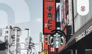 Street view in Japan featuring local signage alongside a Starbucks storefront, illustrating global brands adapting to local language and culture.