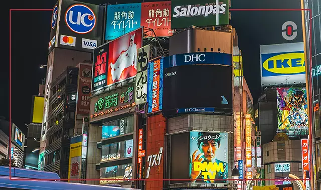 Night scene in Shibuya, Tokyo, filled with colorful billboards and local advertisements, showcasing the vibrant and culturally distinct branding landscape in Asia.
