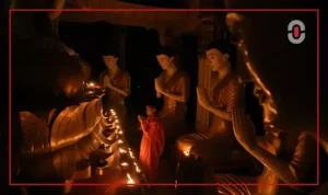 Local monk lighting incense in a temple to honor Queen Sirikit